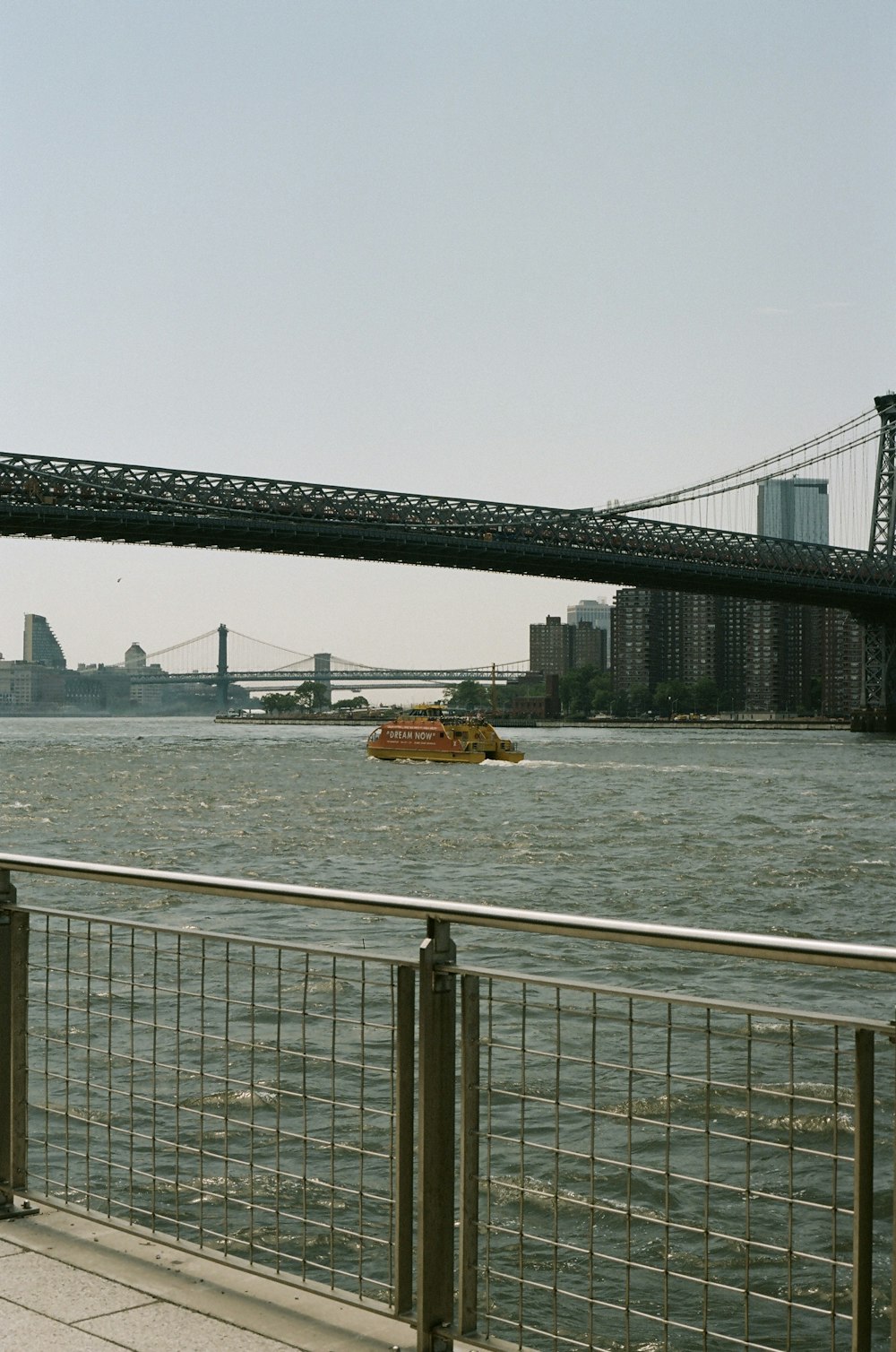 a boat traveling down a river next to a bridge