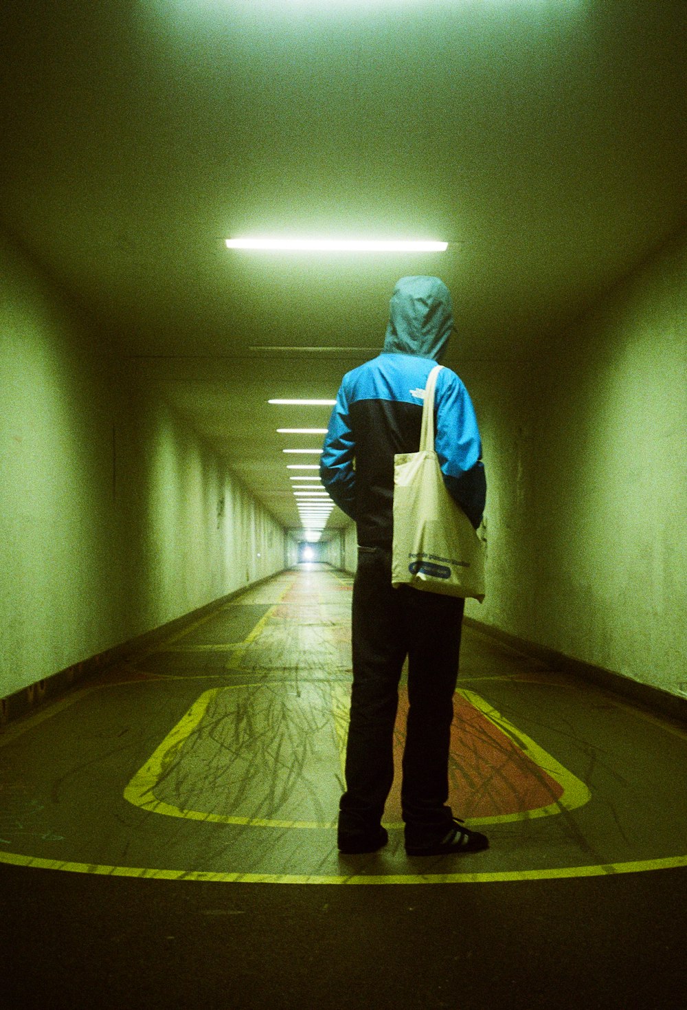 a person standing in a tunnel with a bag