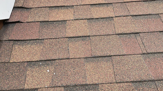 Close-up of roofing tools and shingles laid out neatly on a rooftop.