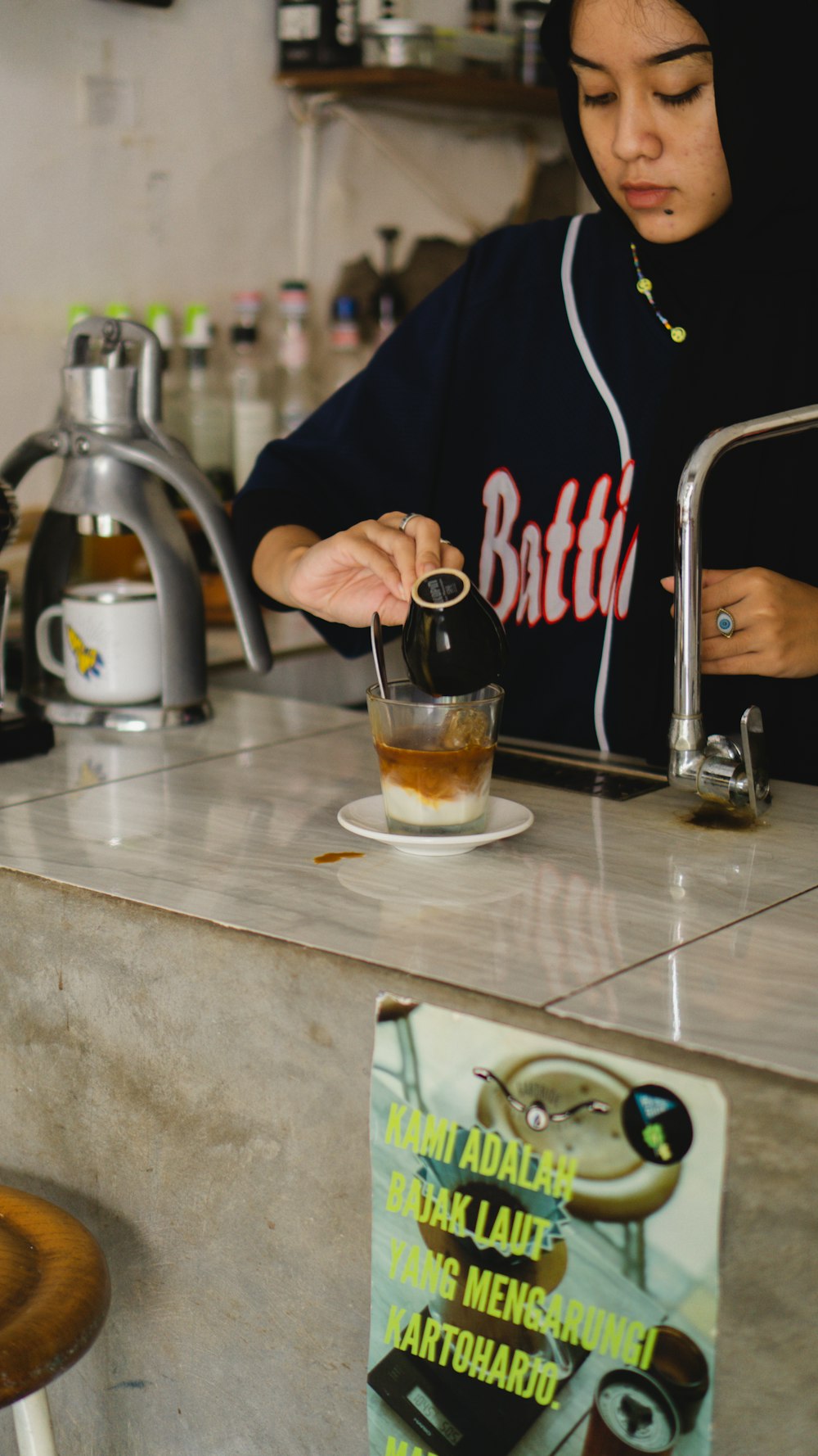 a woman pouring a drink into a glass