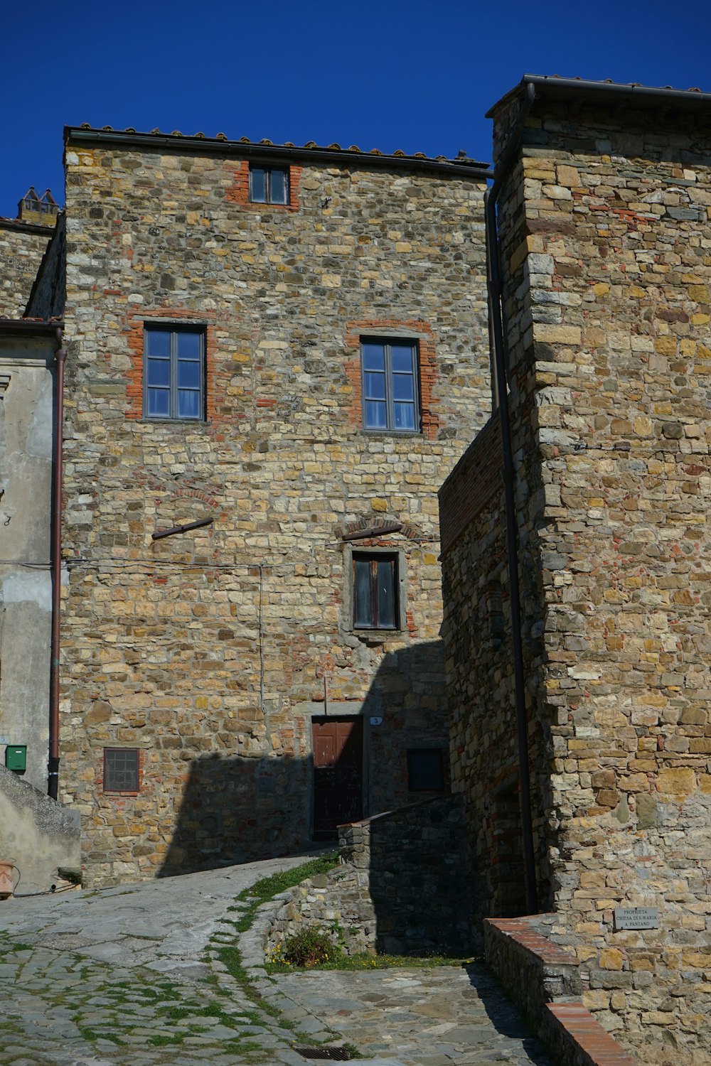 a stone building with a clock on the side of it