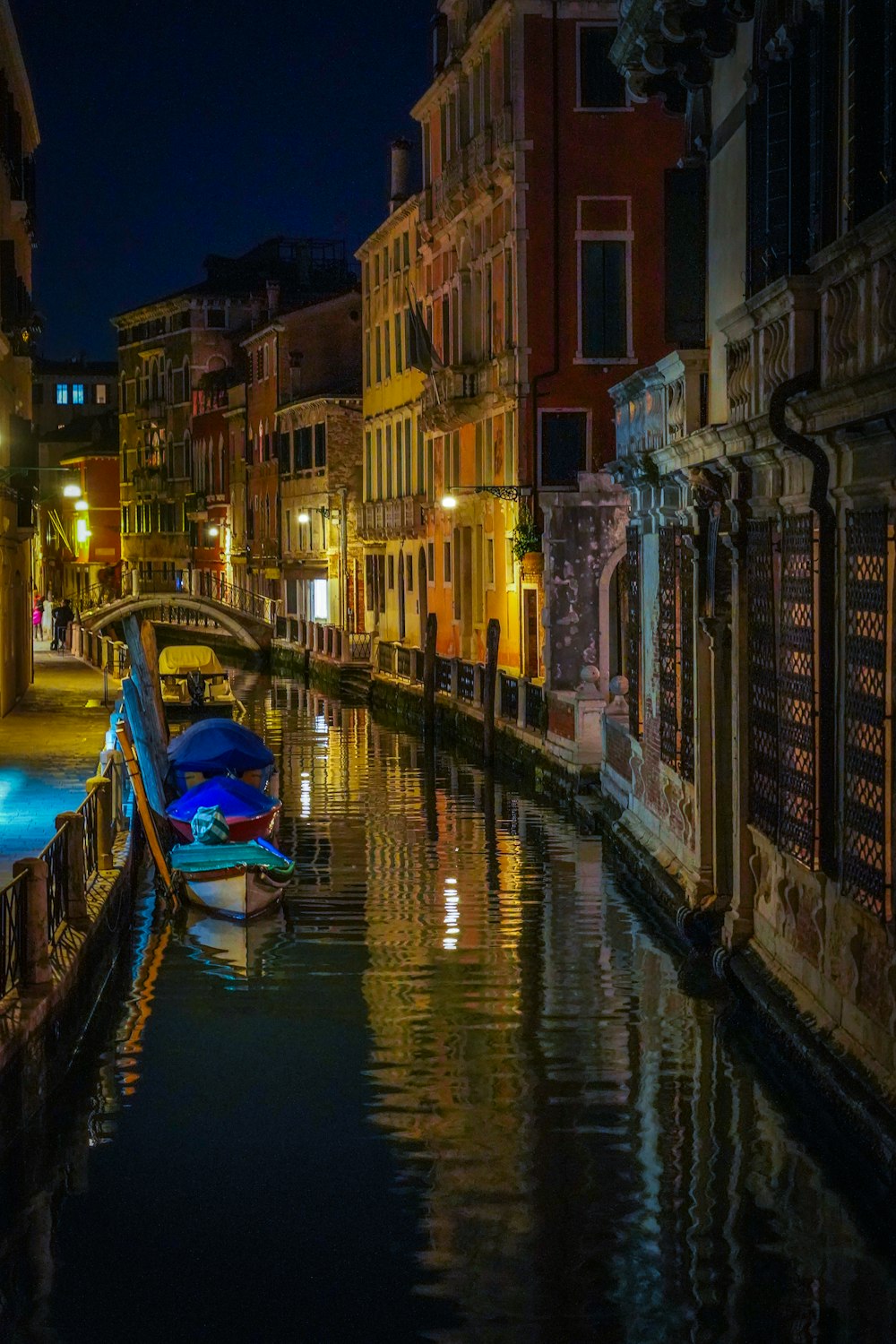 a boat is docked in a canal at night