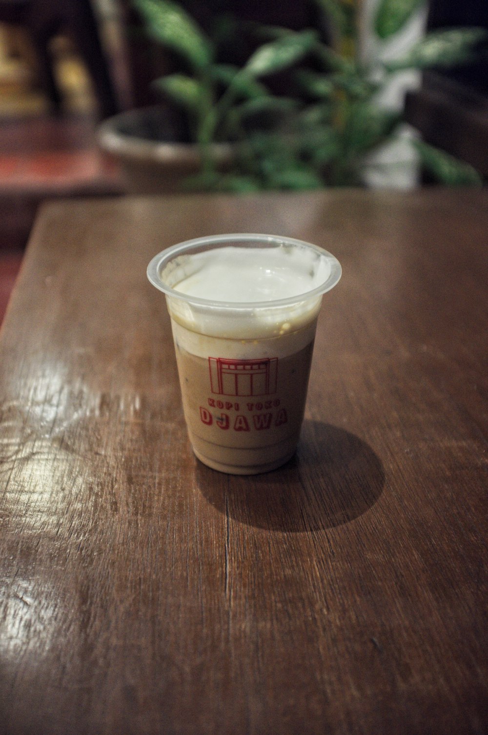 a cup of yogurt sitting on top of a wooden table