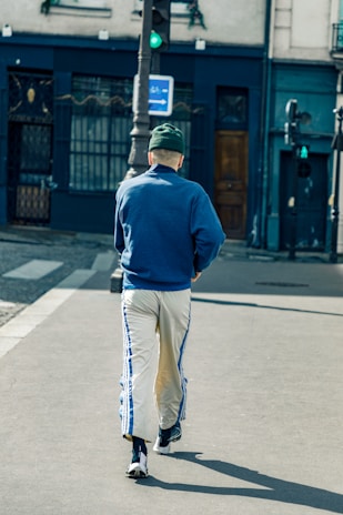 A casual outfit featuring a beige cap worn by a person walking in the city.