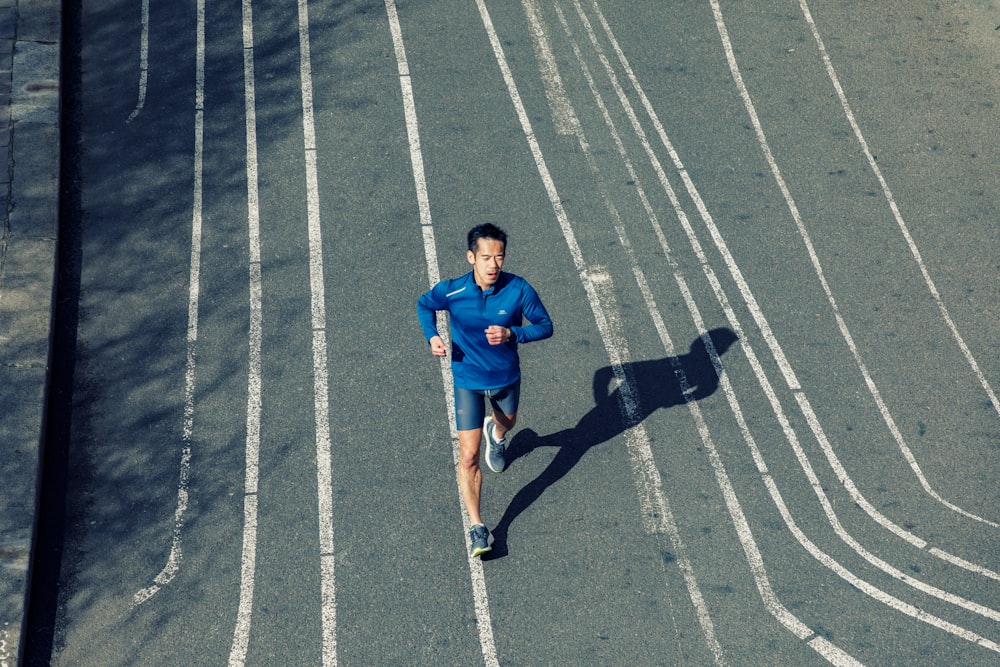 a man running down a street in a blue shirt