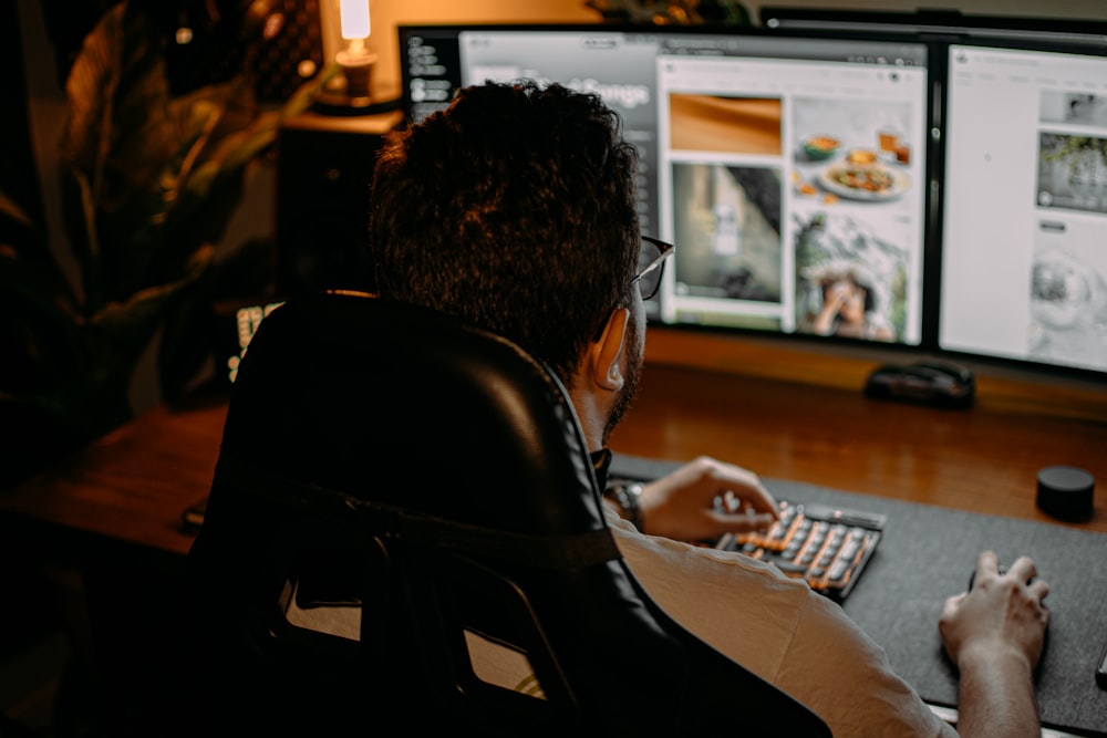 a man sitting in front of a computer monitor