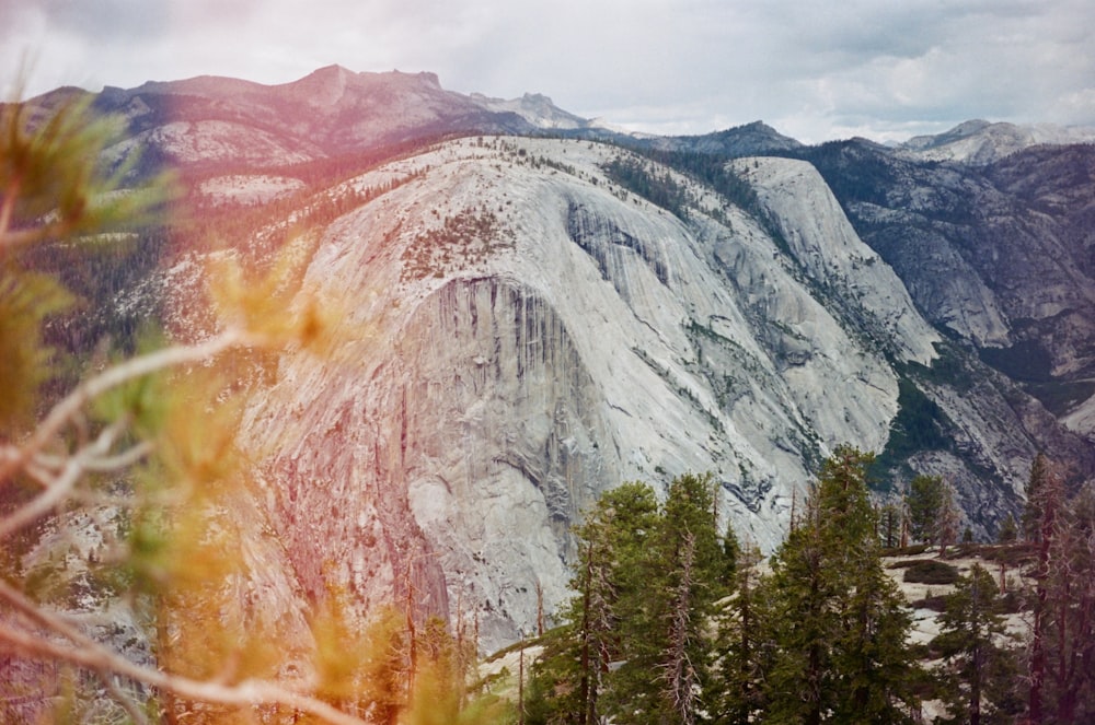 a view of a mountain with trees and mountains in the background