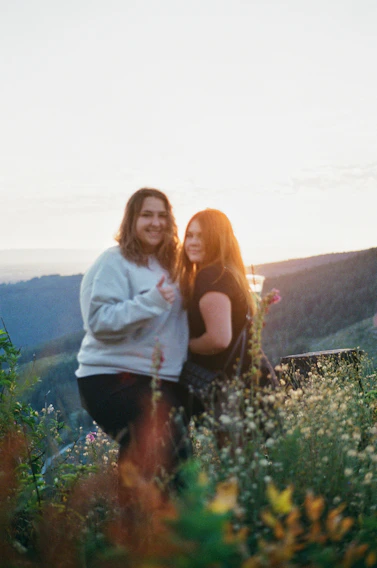 A candid photo of Cynthia and Pierre-Alain laughing together in a lilac field at sunset.