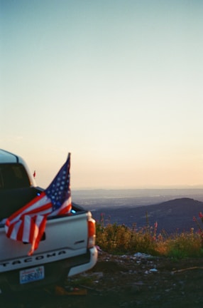 A patriotic-themed truck with the American flag in the background.