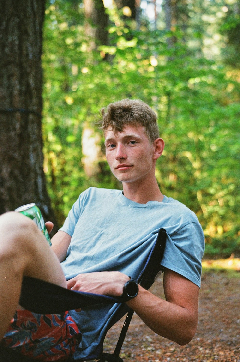 a man sitting in a chair in the woods