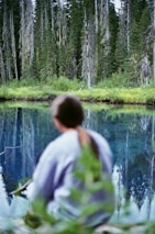 A serene image of a person reflecting in nature, symbolizing personal growth.