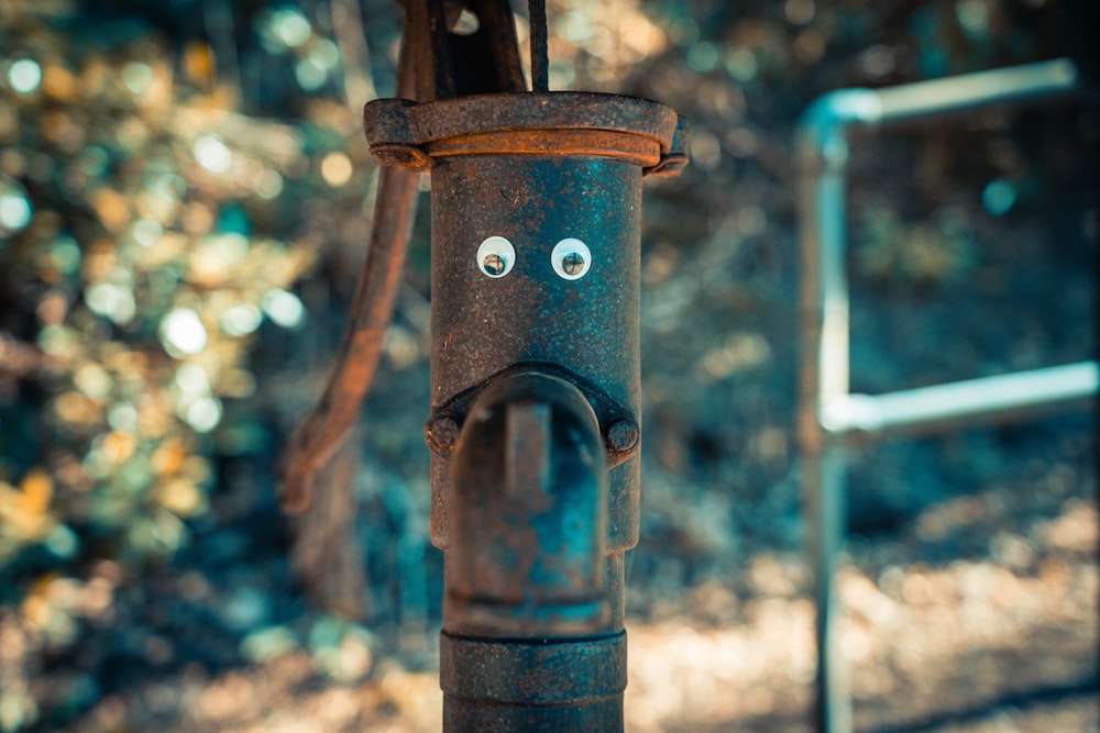 a rusty pipe with a face drawn on it