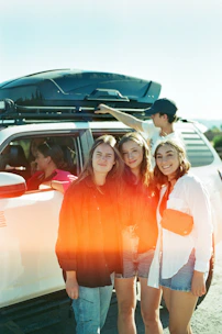 a group of young women standing next to a white van