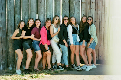 A lively group of young women laughing together at an outdoor cultural event in Fontainebleau.