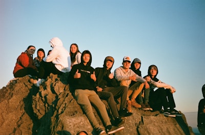 a group of people sitting on top of a rock