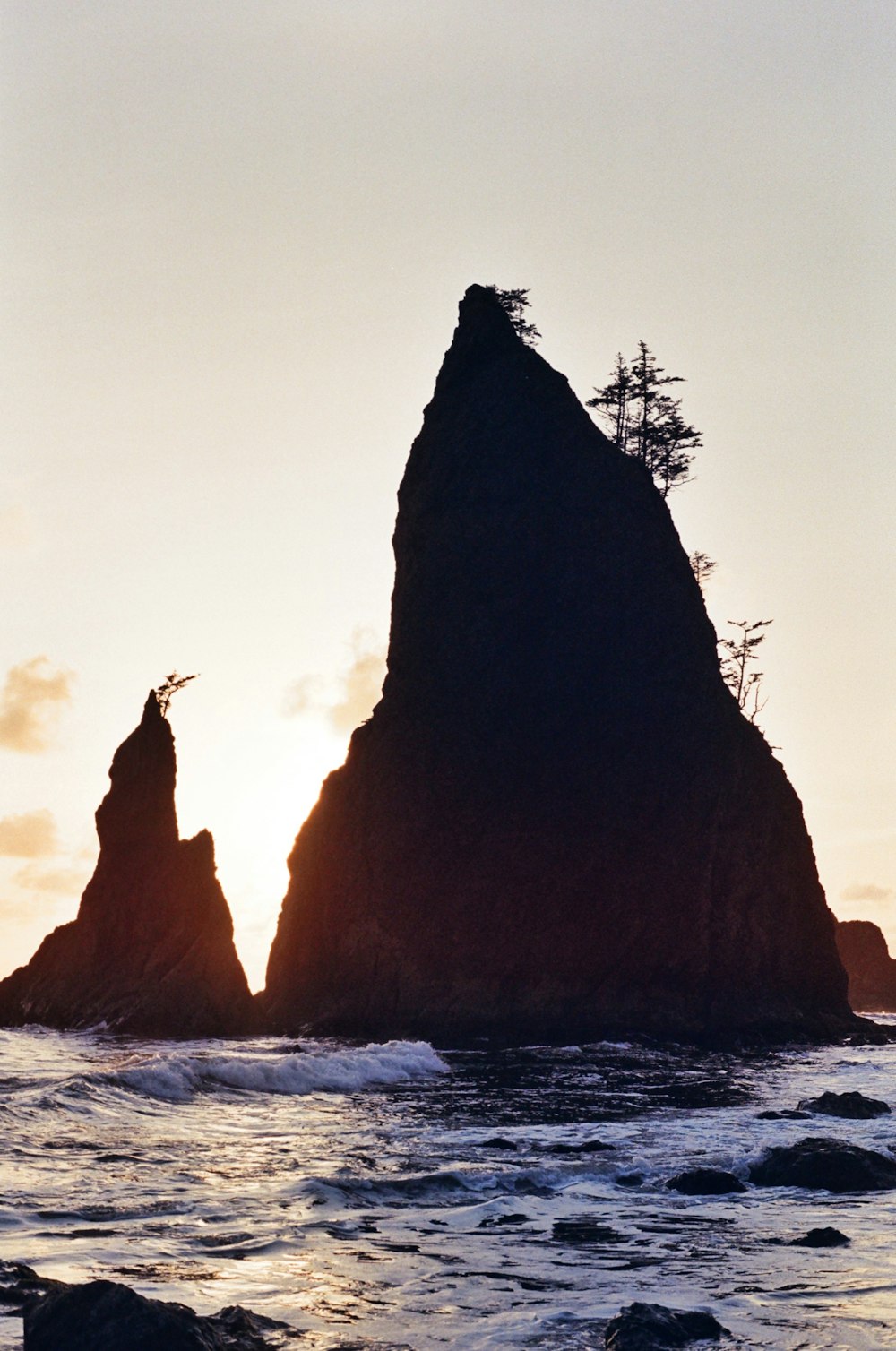 a couple of large rocks sitting in the middle of the ocean