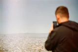 Lifestyle shot of a person using a smart gadget outdoors with a blurred cityscape behind.