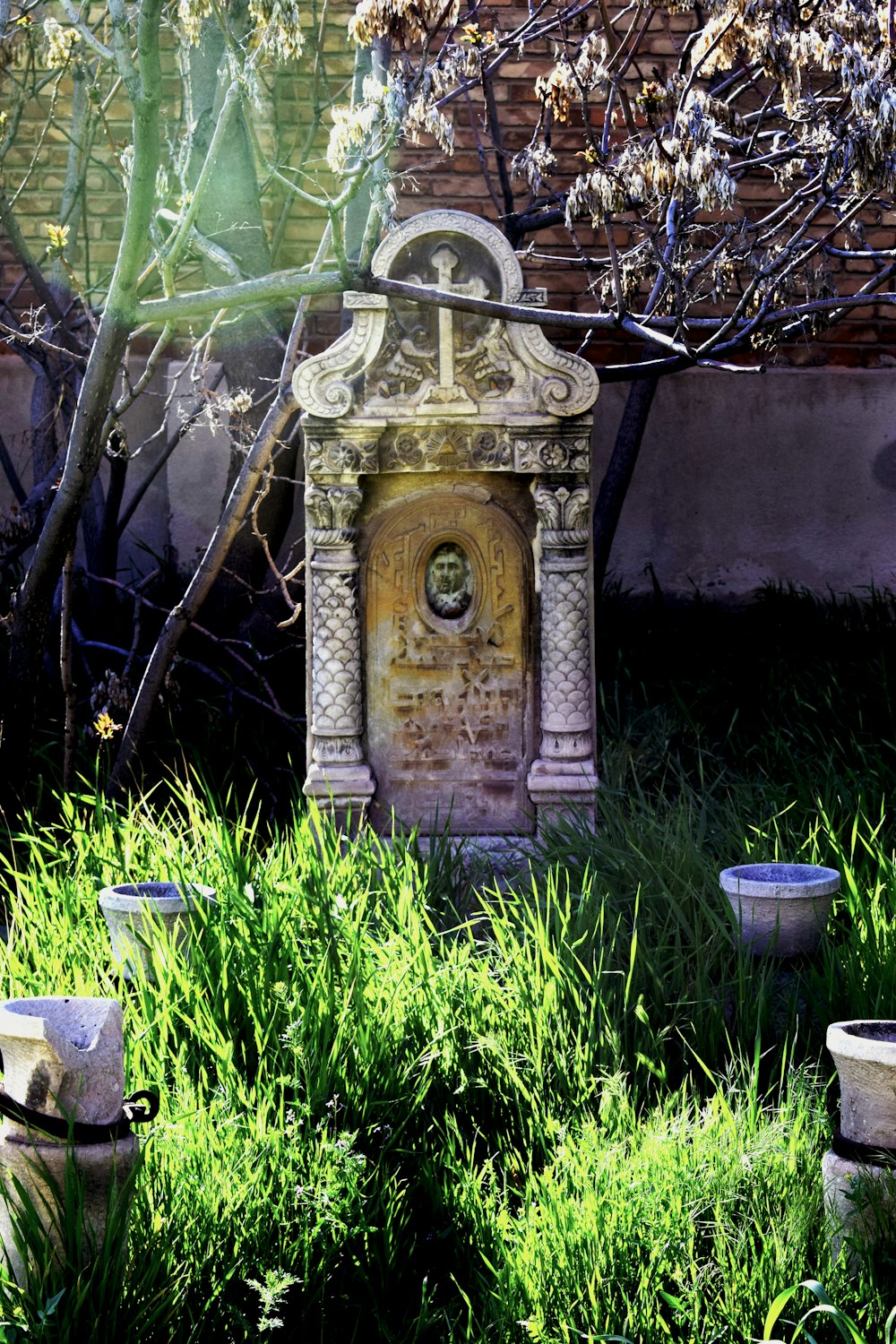 a stone water fountain in the middle of a garden