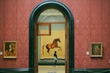 a man standing in front of a painting of a horse
