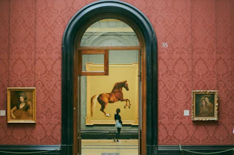 a man standing in front of a painting of a horse