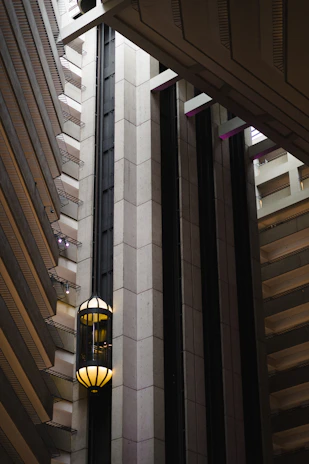 A panoramic view of a high-rise building lobby featuring a premium Fujilift elevator with smooth glass doors.