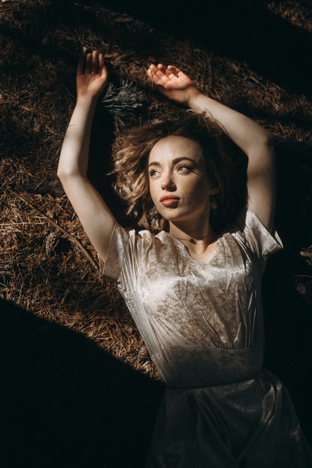 a woman laying on the ground in a white dress