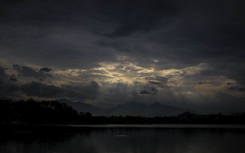 the sun is shining through the clouds over the water