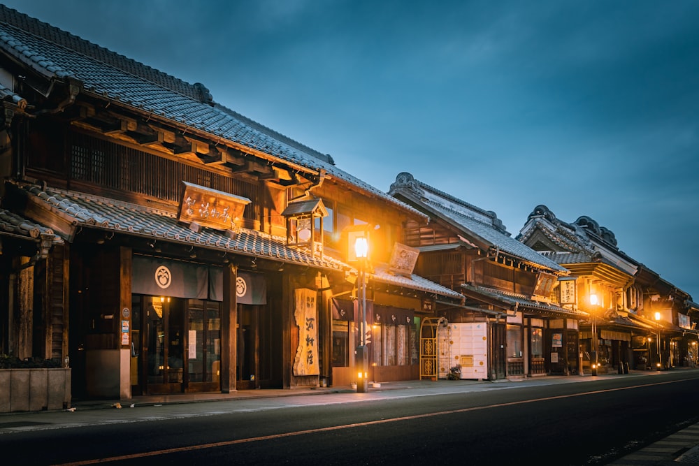 a row of buildings on a street at night