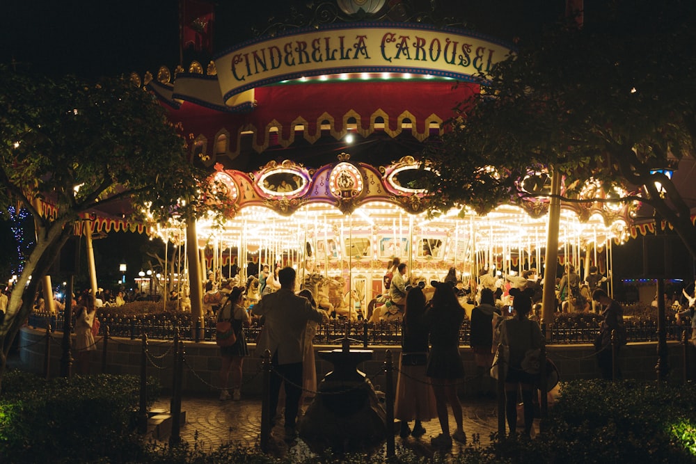 a merry go round at night with people standing around