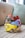 A collection of colorful, intricately designed headbands is stacked on a patterned surface. The headbands feature various designs, including floral patterns, sequins, and beads, with prominent colors of red, blue, and yellow.