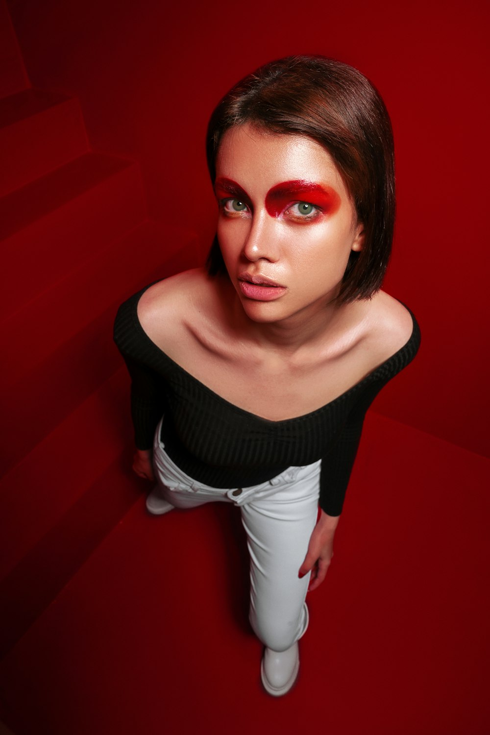 a woman with red makeup and a black top