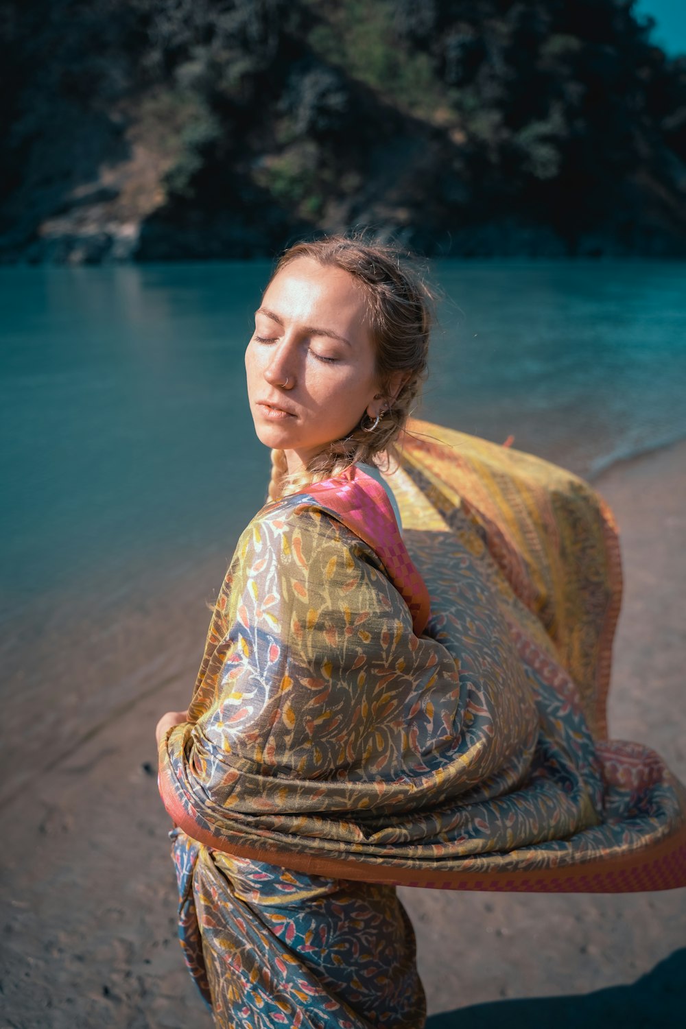 a woman in a sari standing on a beach