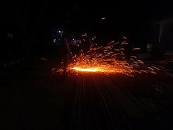 Bright sparks flying from welding work on metal components