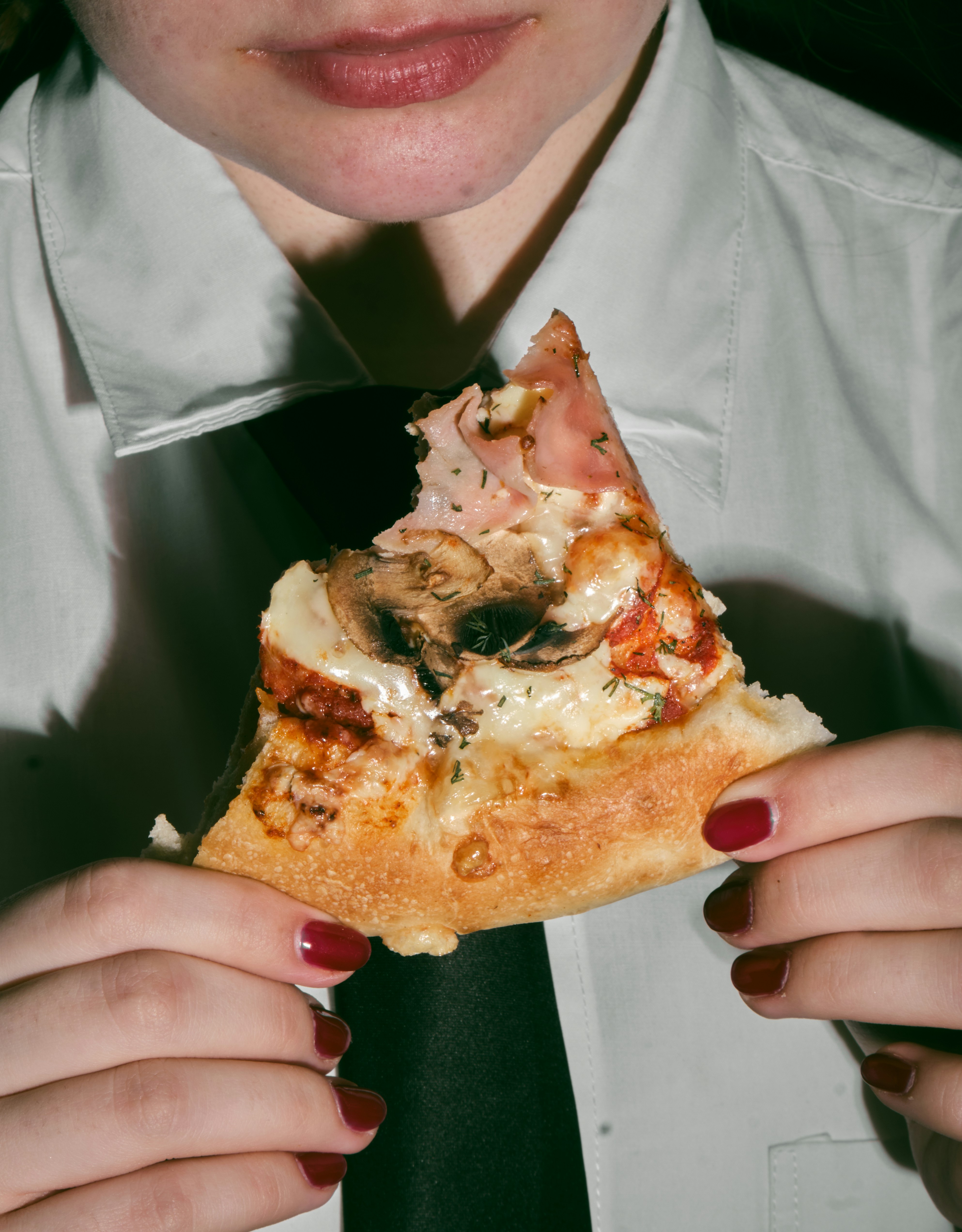 uma mulher segurando uma fatia de pizza em suas mãos