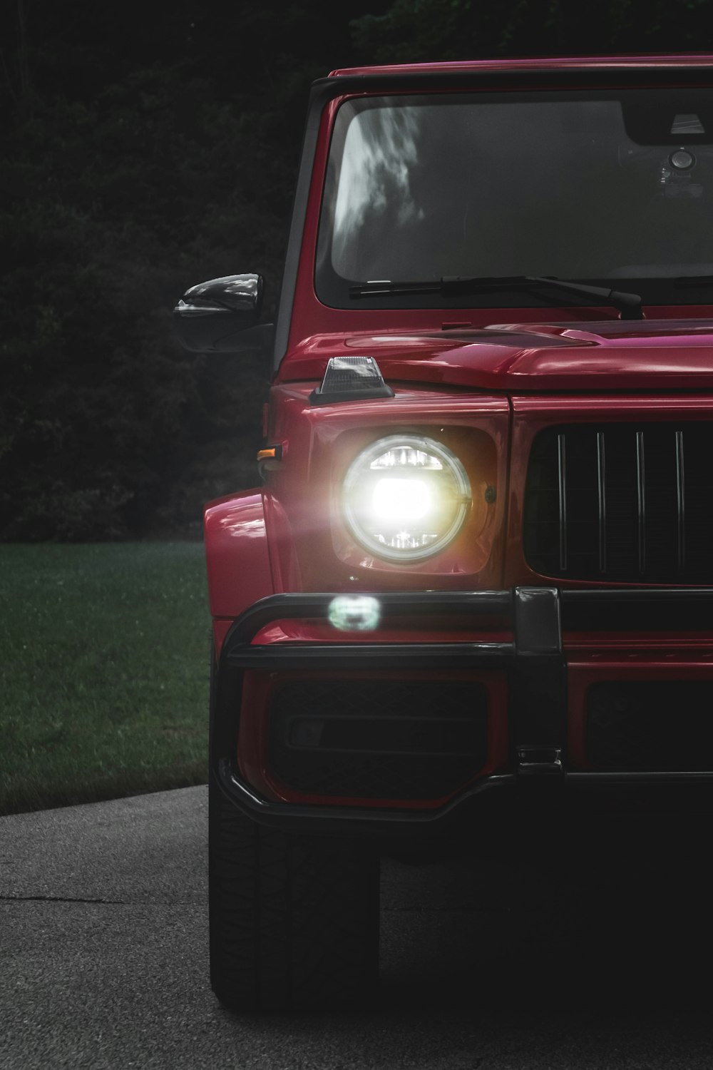 a red jeep is parked on the side of the road