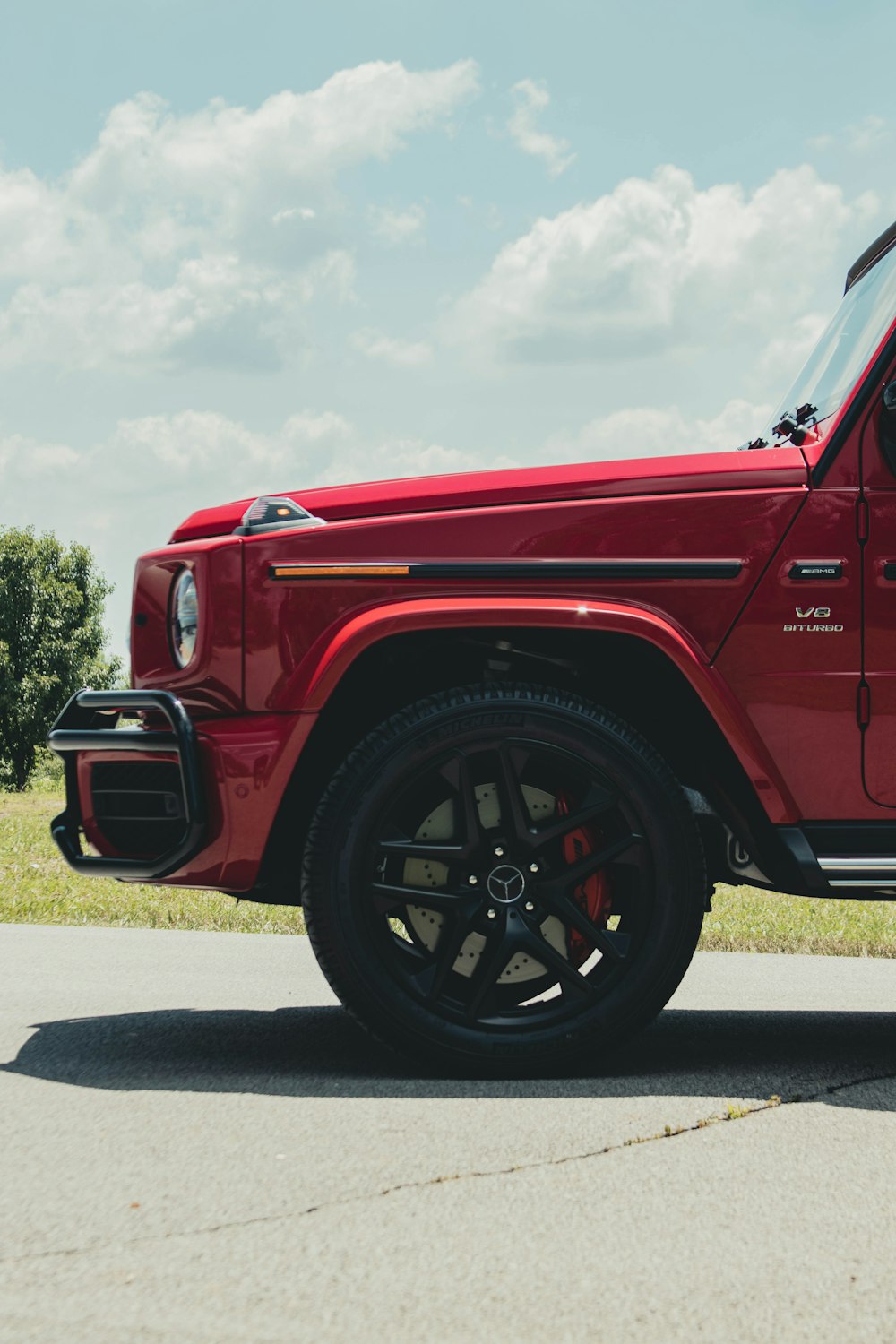 a red jeep parked on the side of a road