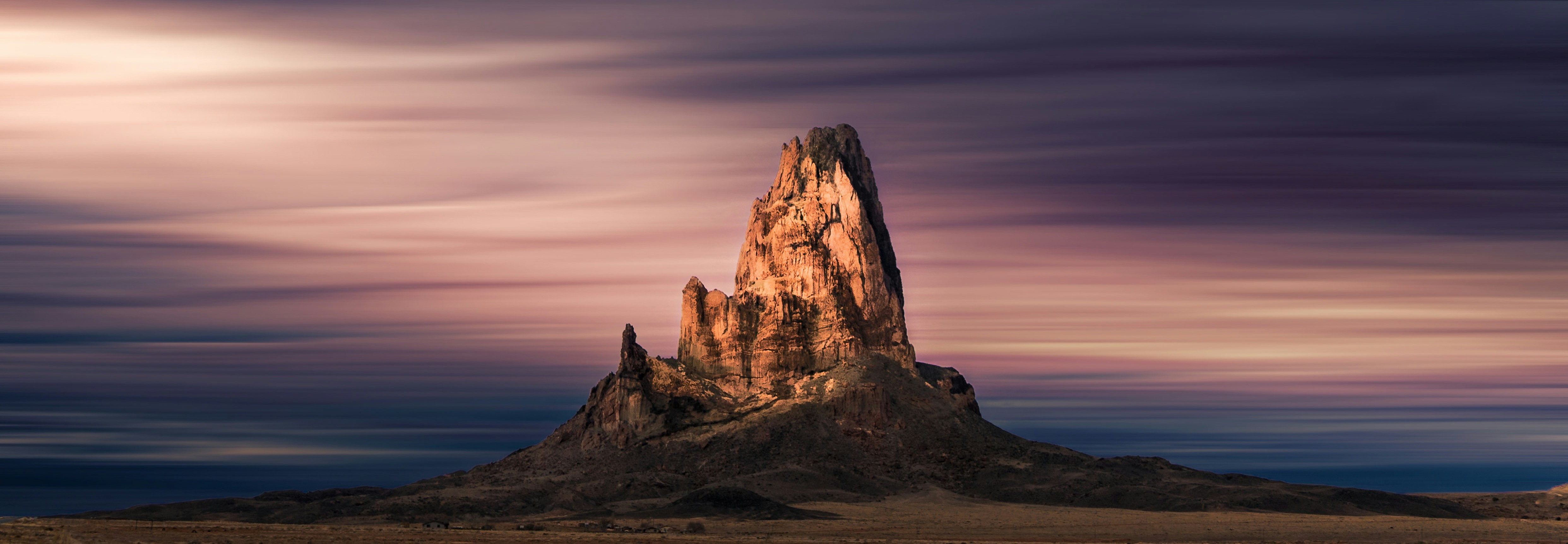 a very tall mountain in the middle of a desert