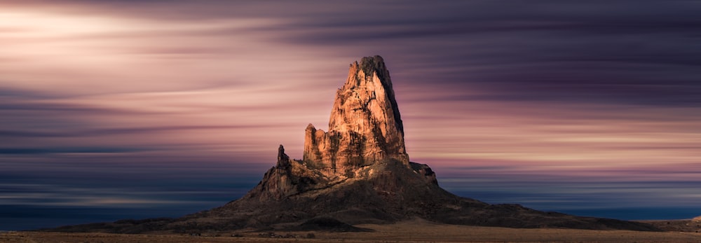 a very tall mountain in the middle of a desert