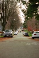 A student carefully navigating a quiet suburban street during a driving lesson.