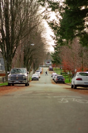 A student carefully navigating a quiet suburban street during a driving lesson.