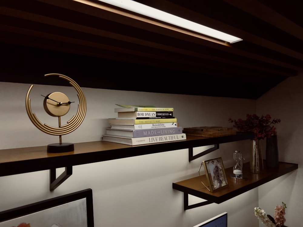 a shelf with books and a clock on top of it