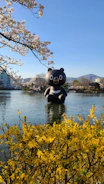 A colorful giant inflatable bear at a lively family event outdoors