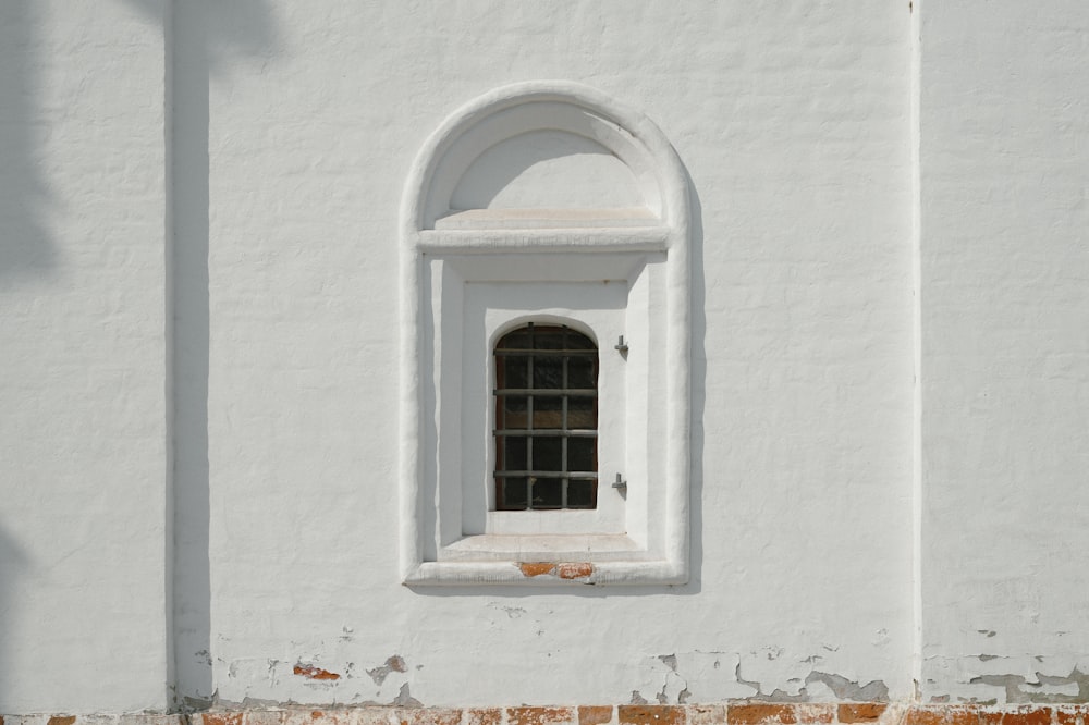 a white building with a window and a brick wall