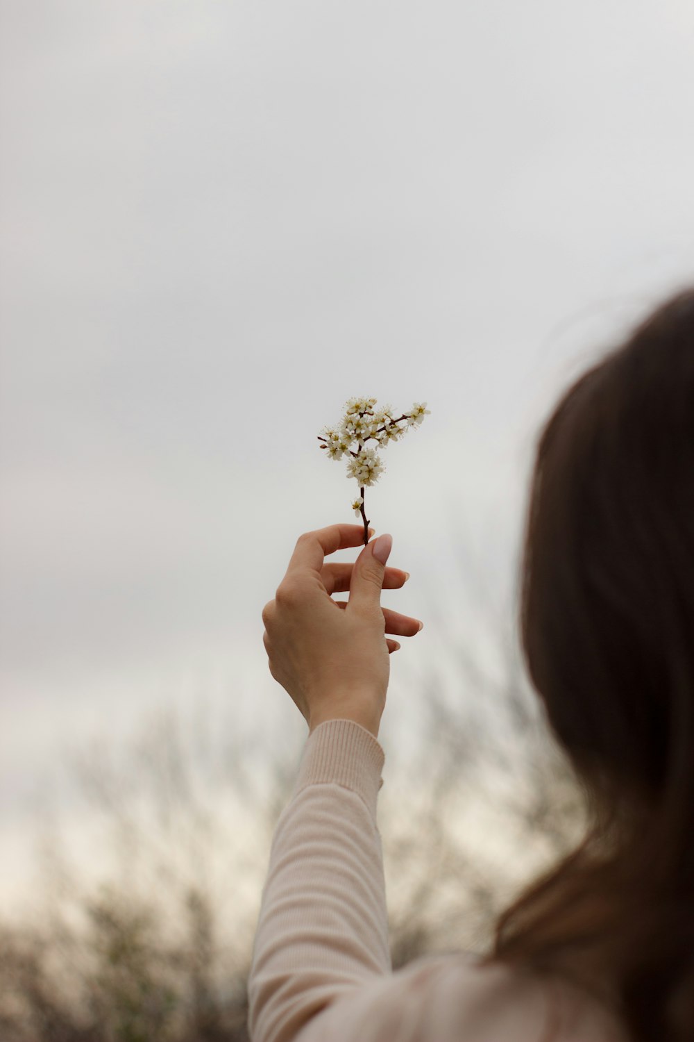 a woman holding a flower in her hand