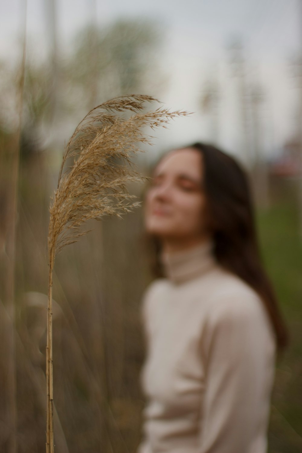 a woman standing in a field of tall grass