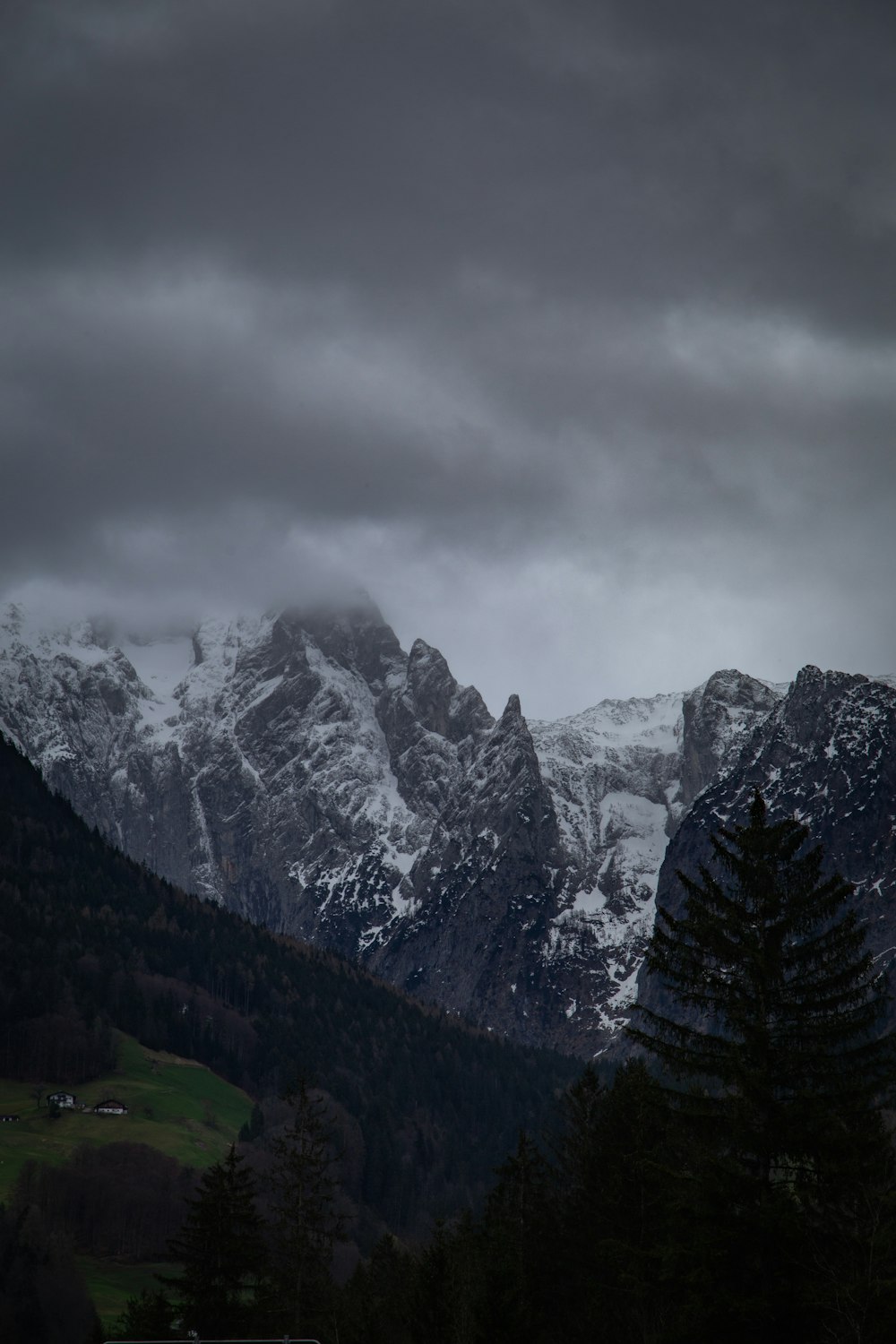 the mountains are covered in snow and clouds