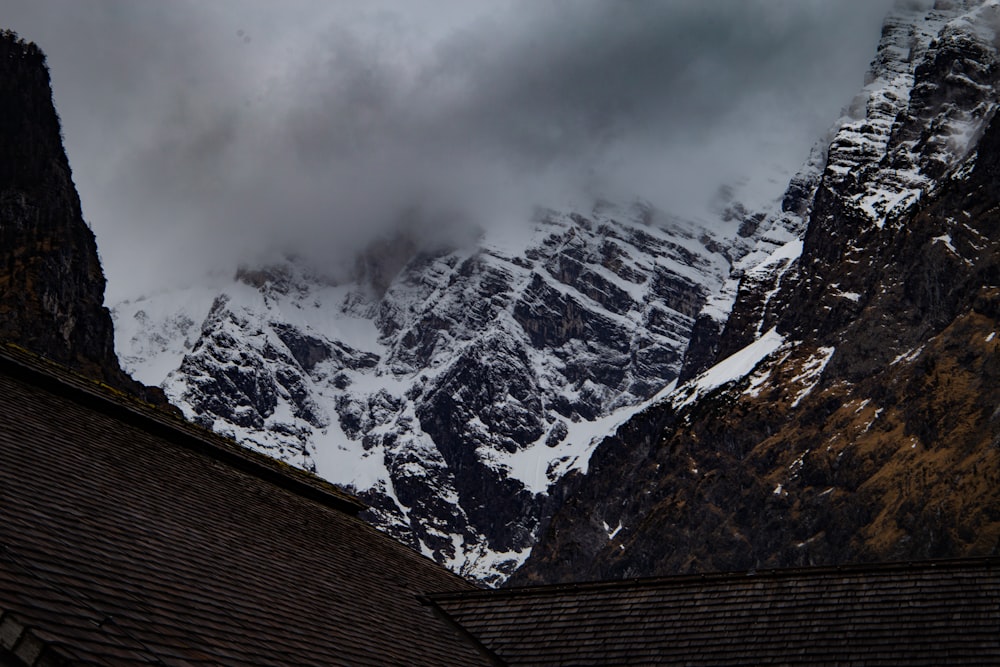a snow covered mountain is seen from the roof of a house