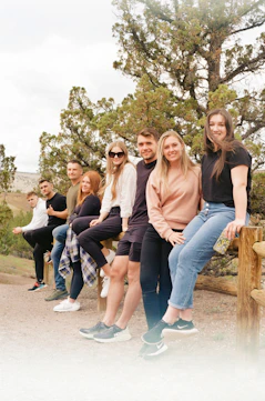 a group of people sitting on a wooden bench
