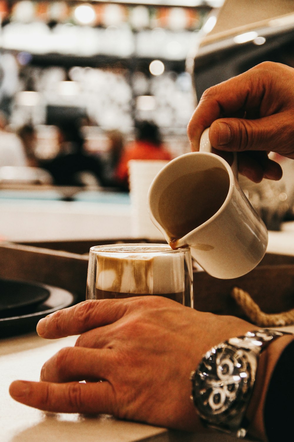 a person pours coffee into a glass