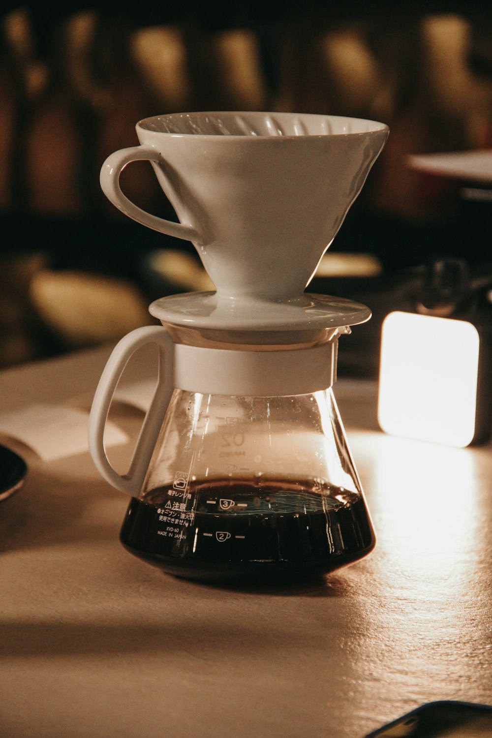 a coffee maker with a cup of coffee in front of it